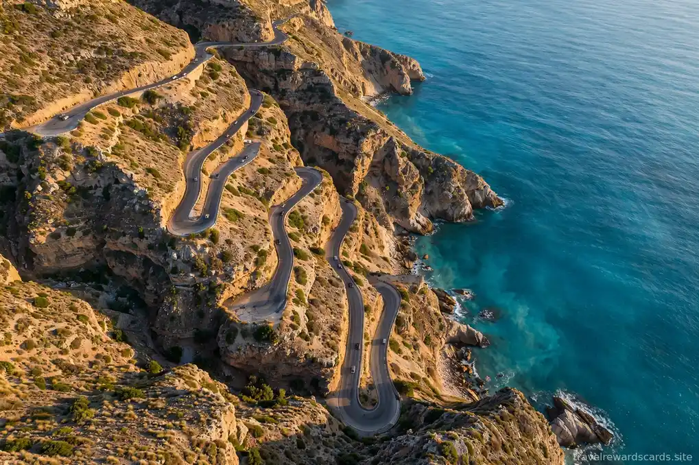 Vista aérea de una carretera serpenteante junto al mar turquesa