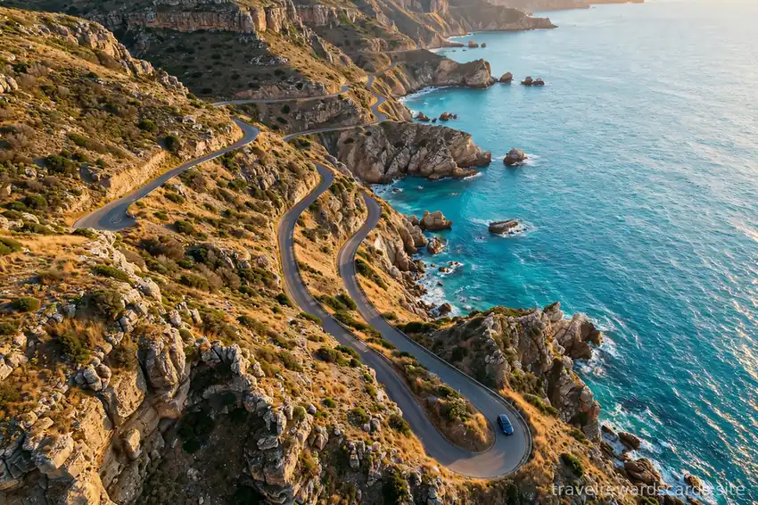 Vista aérea de una carretera sinuosa junto a acantilados y el mar turquesa
