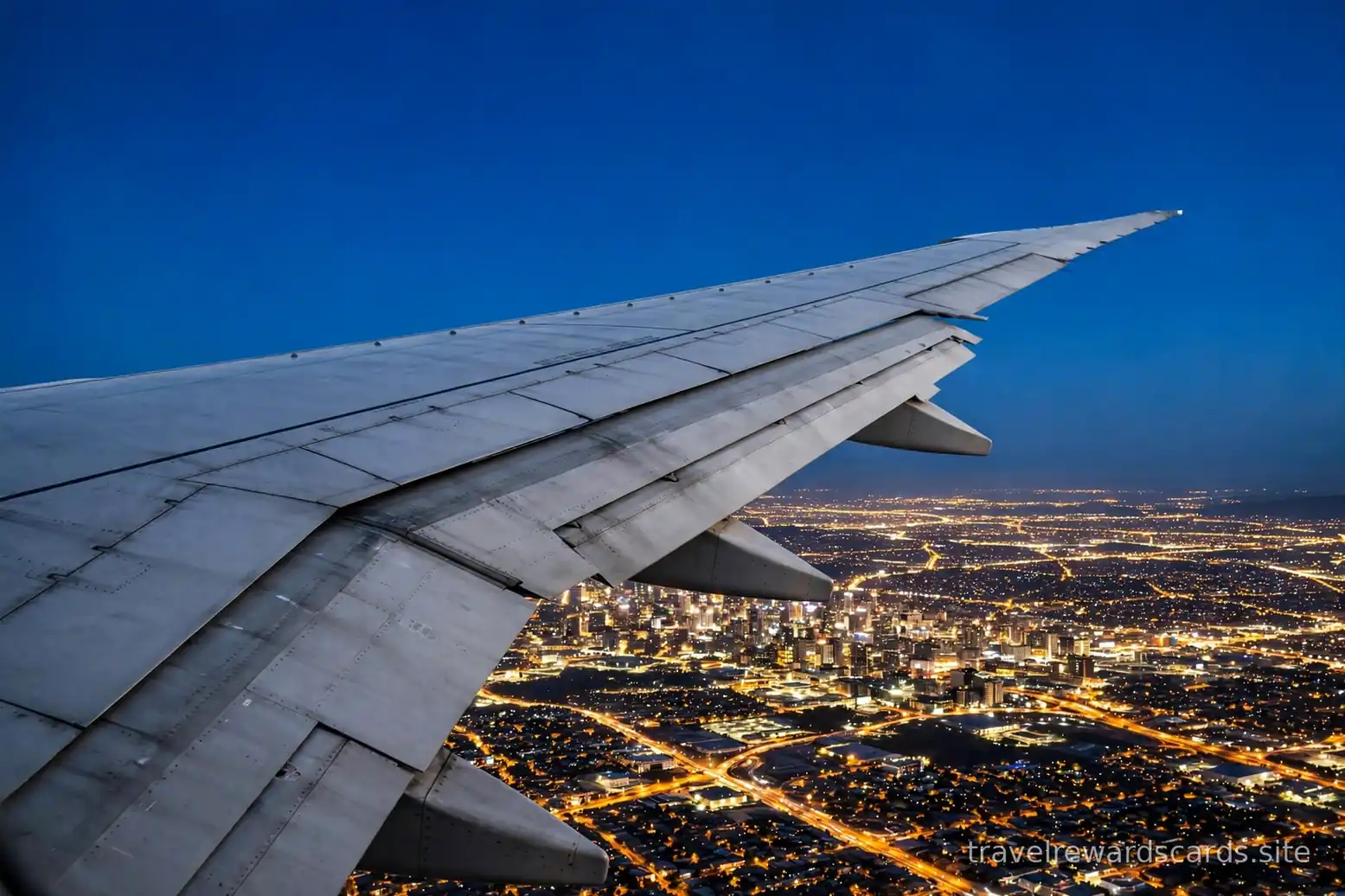 Ala de avión sobre luces de ciudad de noche
